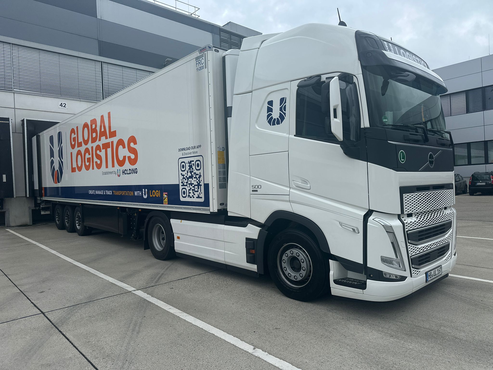 Volvo FH mit Global-Logistics-Kühlauflieger an der Laderampe